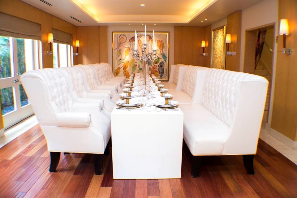 Luxury event furniture cost example with white tufted dining chairs, banquet seating, and elegant tabletop décor.